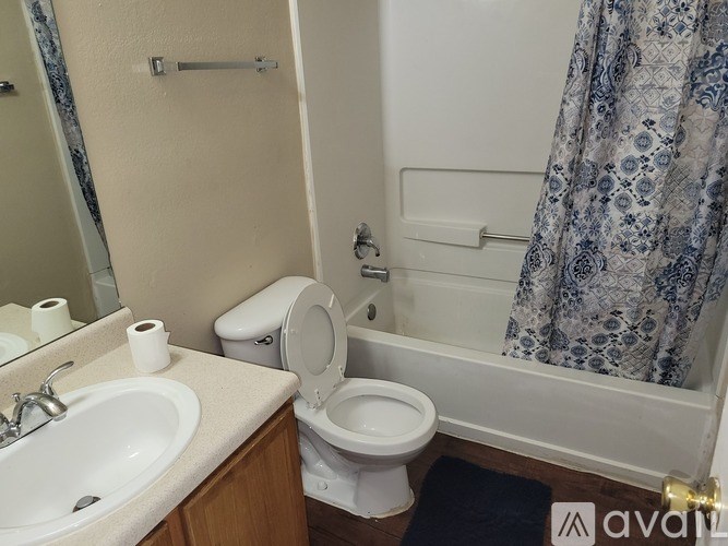 A bathroom with a toilet, sink, and shower.