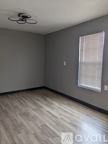 A room with a ceiling fan and a window with blinds.