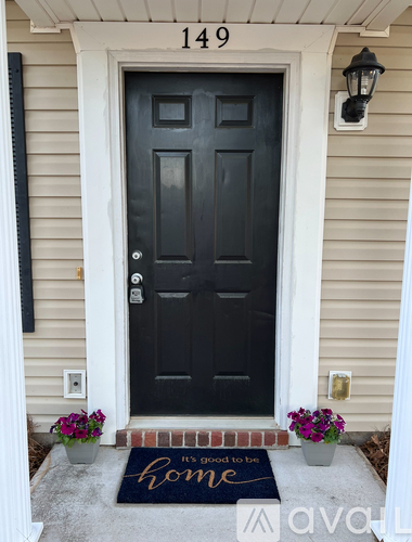 A black door with a mat that says home on it.