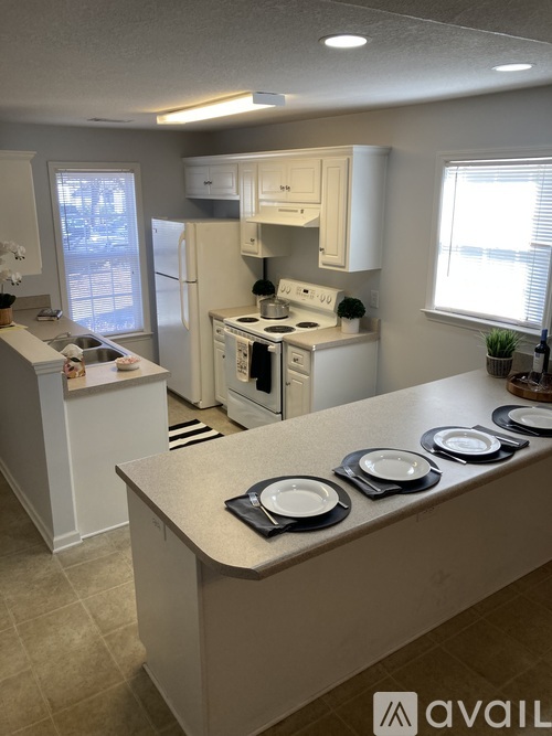 A kitchen with white appliances and a white counter.