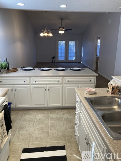 A kitchen with white cabinets and a black and white striped rug.