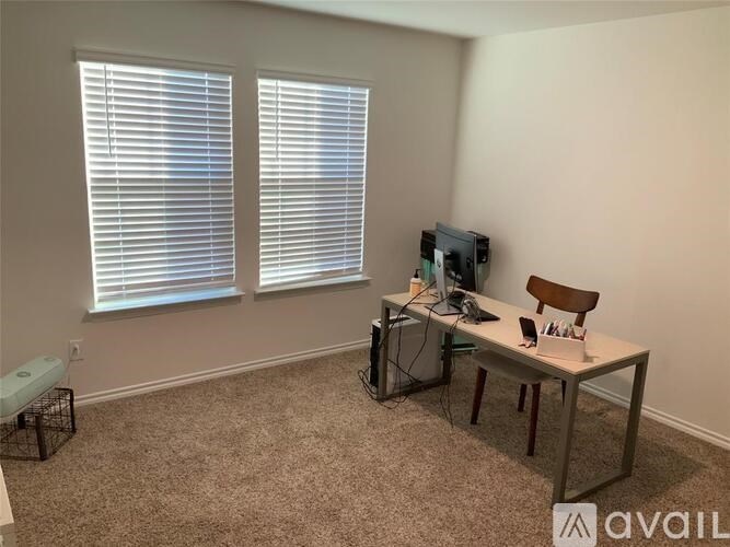 A room with a desk, chair, and computer setup.