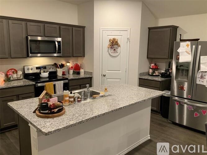 A kitchen with a granite countertop and a fridge with magnets on it.