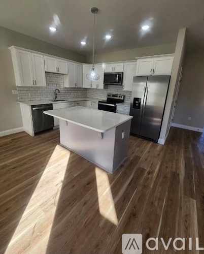 A kitchen with wooden floors and white cabinets.