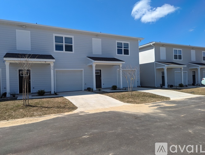 A row of modern townhouses with a clear blue sky above.