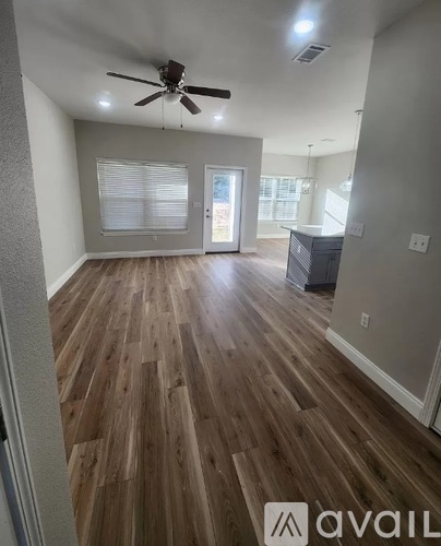 A room with wooden flooring and a ceiling fan.