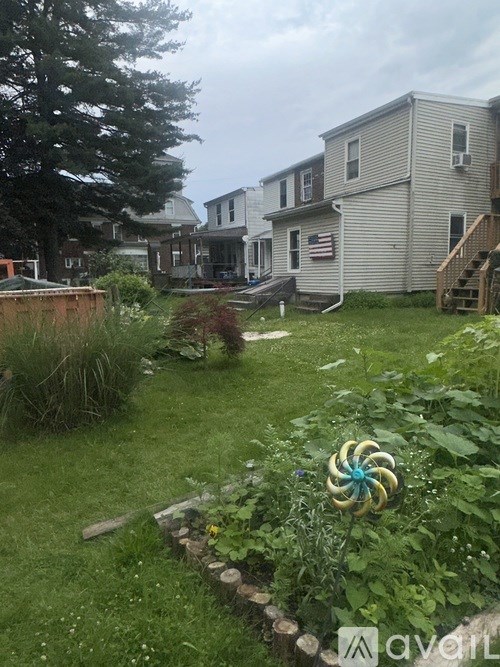 A backyard with a flag on a pole and a garden.