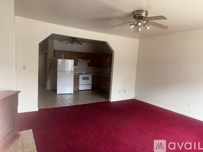 A room with a red carpet and a ceiling fan.