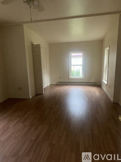 A room with wooden flooring and a window.