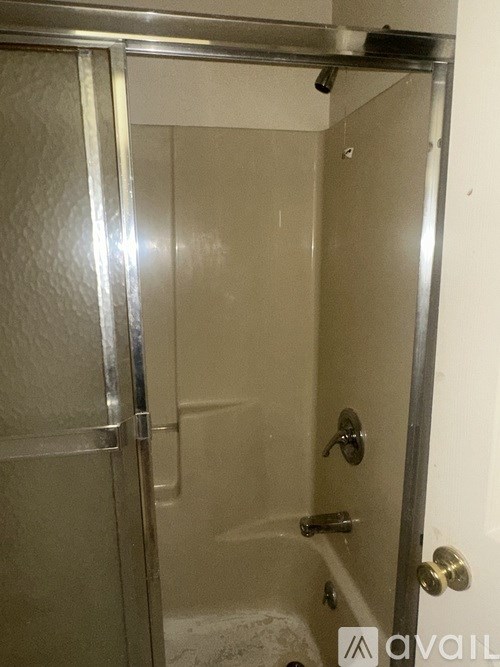 A shower stall with a glass door and a metal frame.