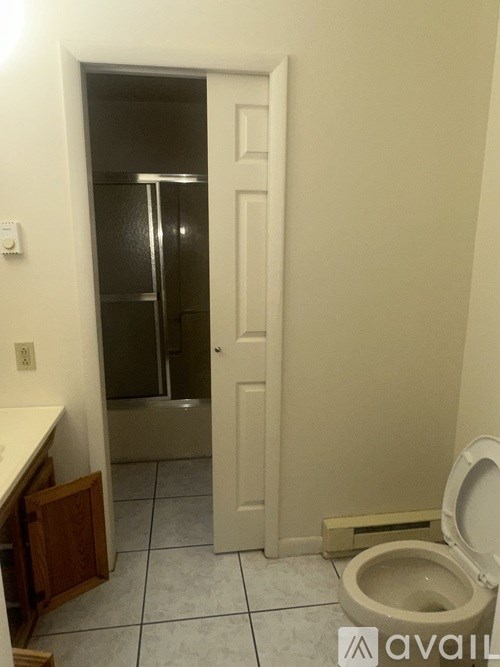 A bathroom with a toilet, sink, and shower stall.