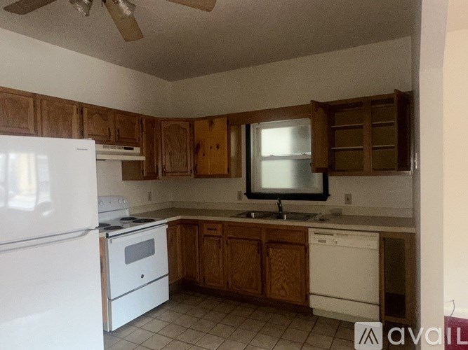 A kitchen with wooden cabinets and white appliances.