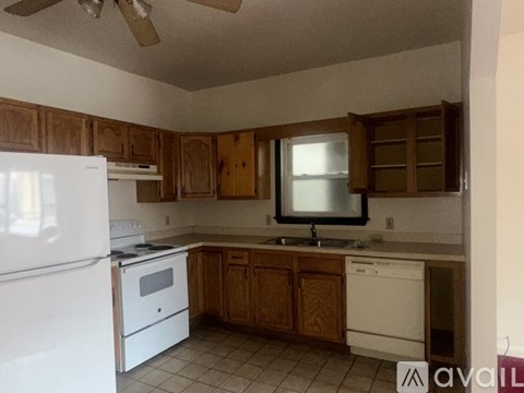 A kitchen with wooden cabinets and white appliances.
