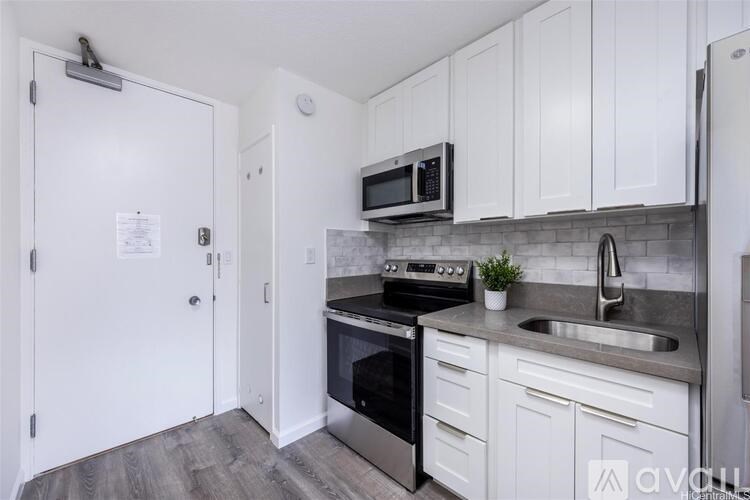 A kitchen with white cabinets and stainless steel appliances.