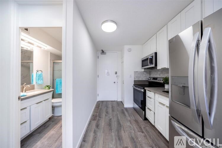 A kitchen with white cabinets and a refrigerator.