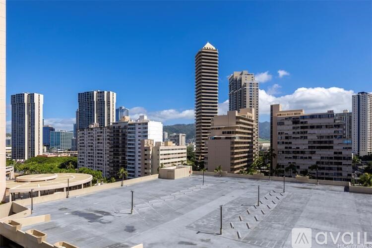 A cityscape with a large open parking lot in the foreground.