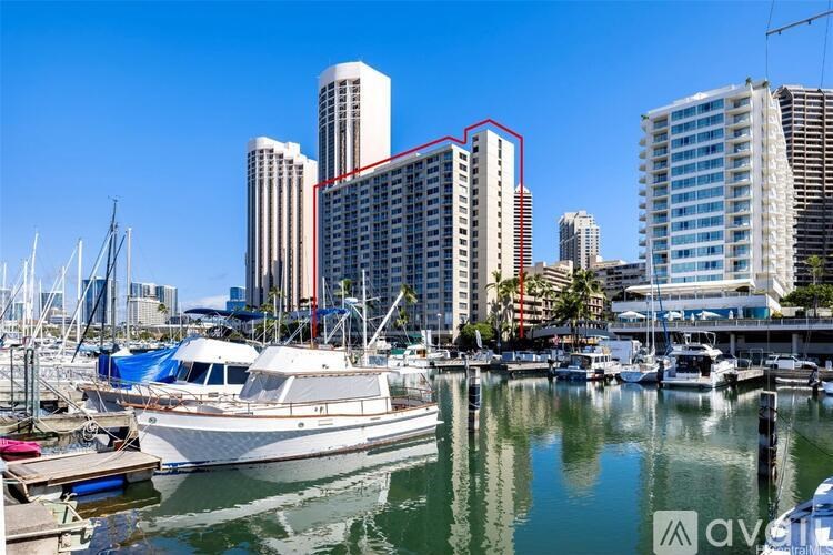 A boat is docked in a marina with a city skyline in the background.