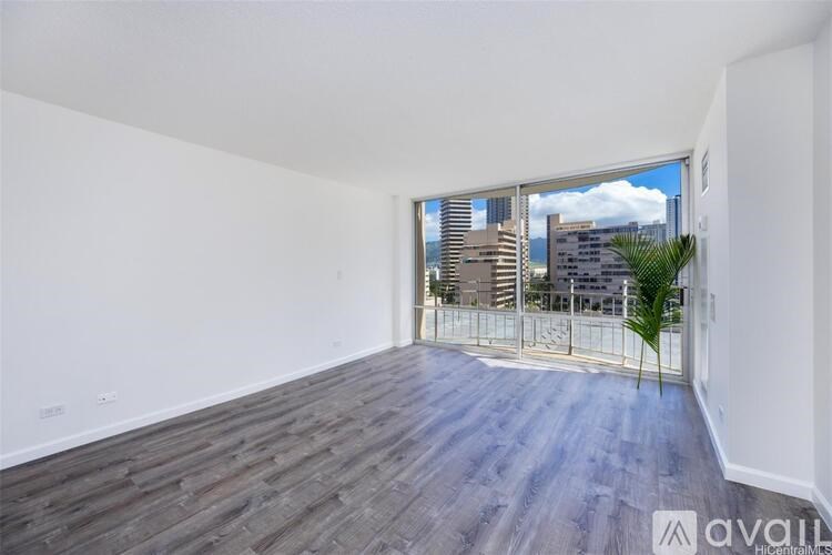 A room with wooden flooring and a large window overlooking a cityscape.
