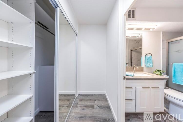 A bathroom with a sink, mirror, and a refrigerator.