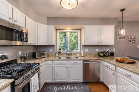 A kitchen with white cabinets and a black stove top.