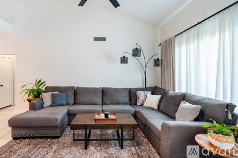 A living room with a grey sofa and a wooden coffee table.