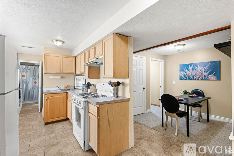 A kitchen with wooden cabinets and a dining table with chairs.