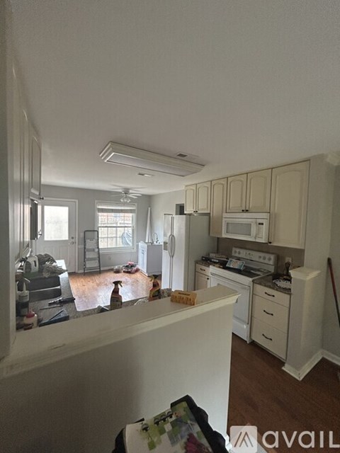 A kitchen with white appliances and cabinets.