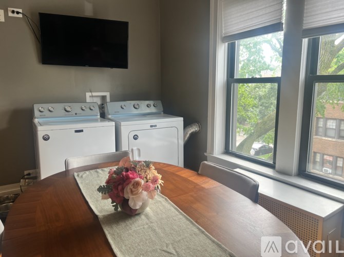 A room with two washing machines and a TV mounted on the wall.