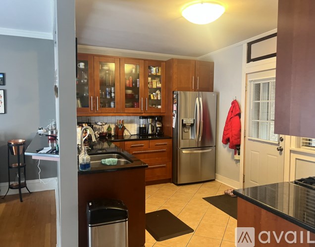 A kitchen with wooden cabinets and a stainless steel refrigerator.
