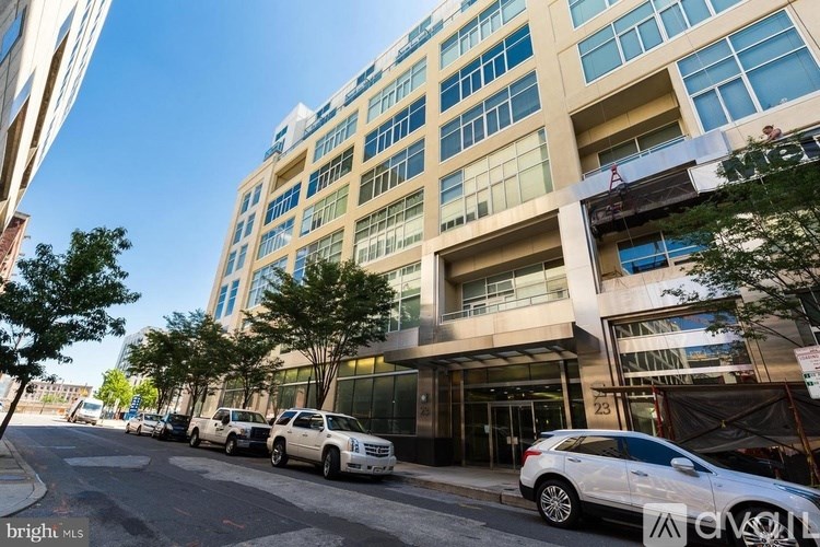 A street view of a building with cars parked in front.
