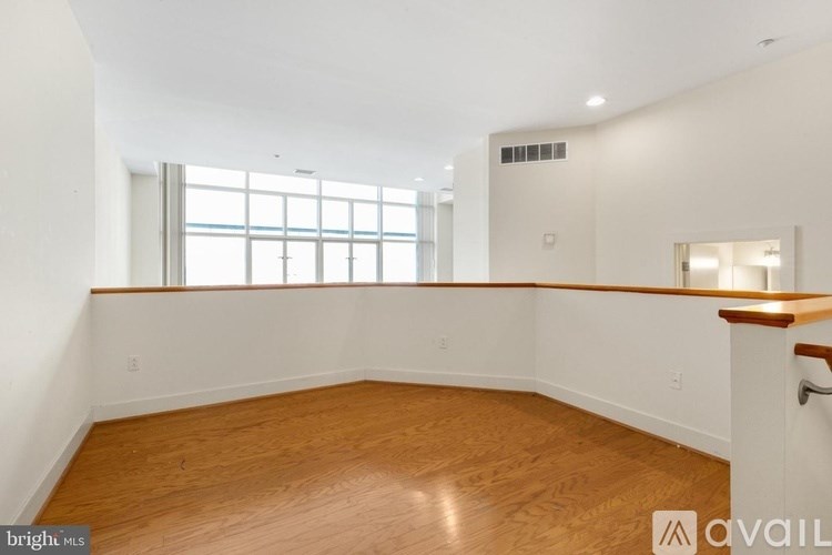A room with wooden flooring and a window with blinds.