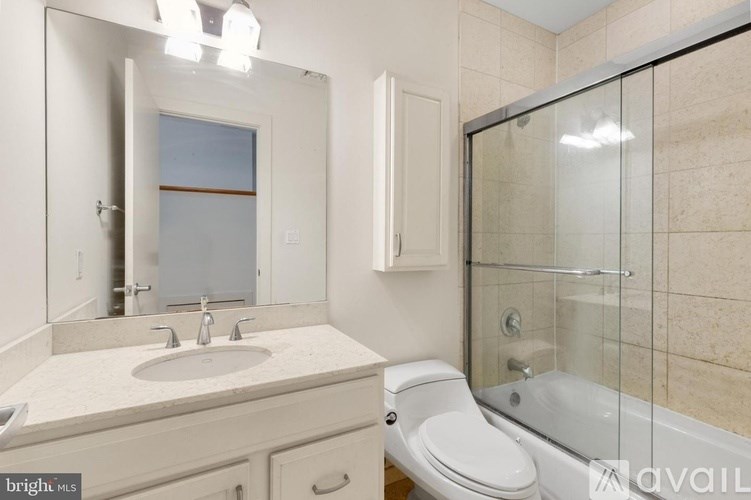 A bathroom with a sink, toilet, and shower.