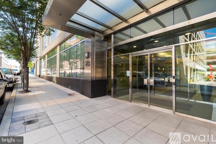 A modern building entrance with glass doors and a glass roof.