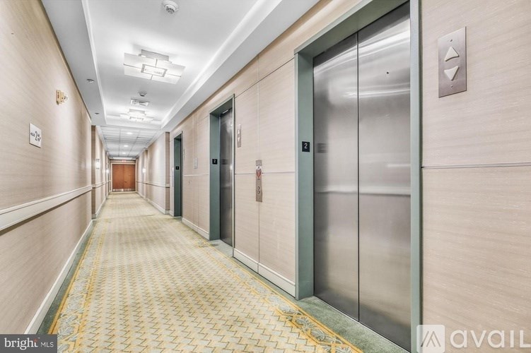 A long hallway with a metal elevator on the right.