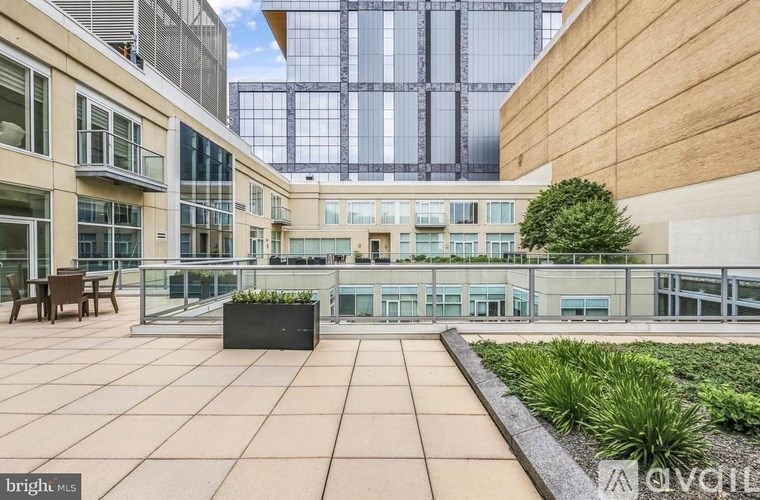 A modern courtyard with a glass wall and a green planter.