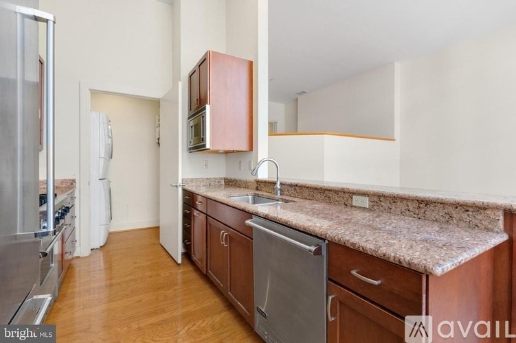 A kitchen with wooden cabinets and a granite countertop.