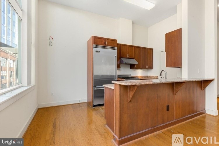 A kitchen with wooden cabinets and a refrigerator.
