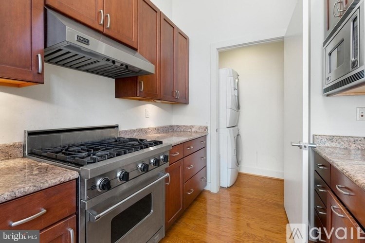 A kitchen with a stove top oven and a refrigerator.