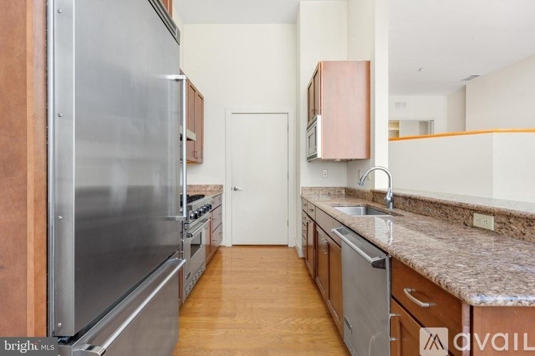 A kitchen with a refrigerator, oven, and sink.