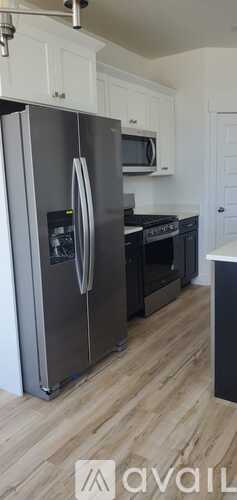 A kitchen with white cabinets and a marble backsplash.