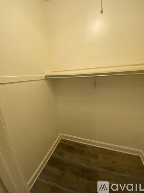 A room with a wooden floor and a white wall.