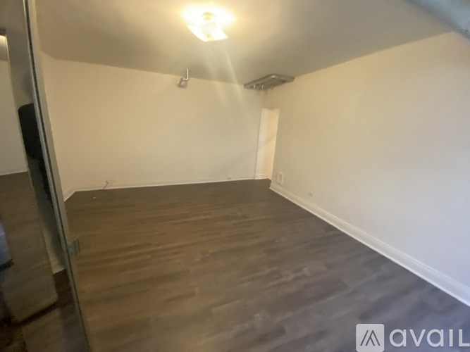 A room with wooden flooring and white walls.
