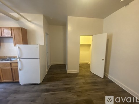 A kitchen area with a white refrigerator and wooden cabinets.