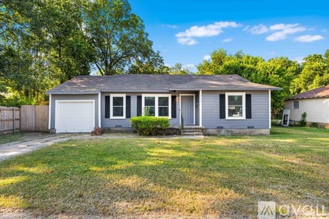 A house with a grey roof and a white garage door.