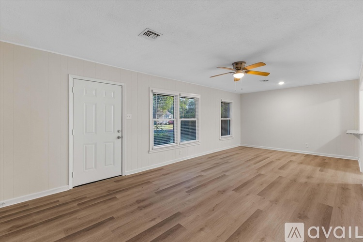 A room with a ceiling fan and wooden flooring.