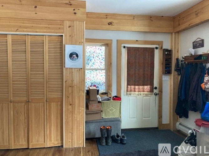 A room with wooden walls and a white door.