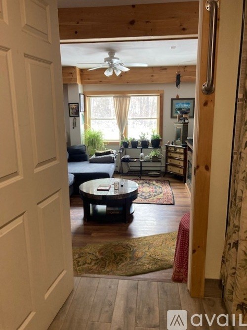 A living room with a couch, coffee table, and a ceiling fan.