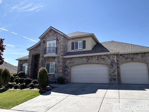A large house with a stone facade and two garages.