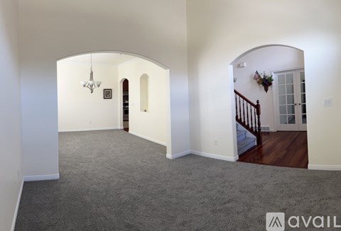 A spacious room with a staircase leading to the second floor.