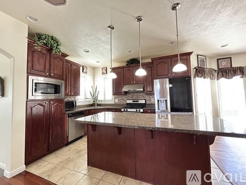 A kitchen with brown cabinets and granite countertops.